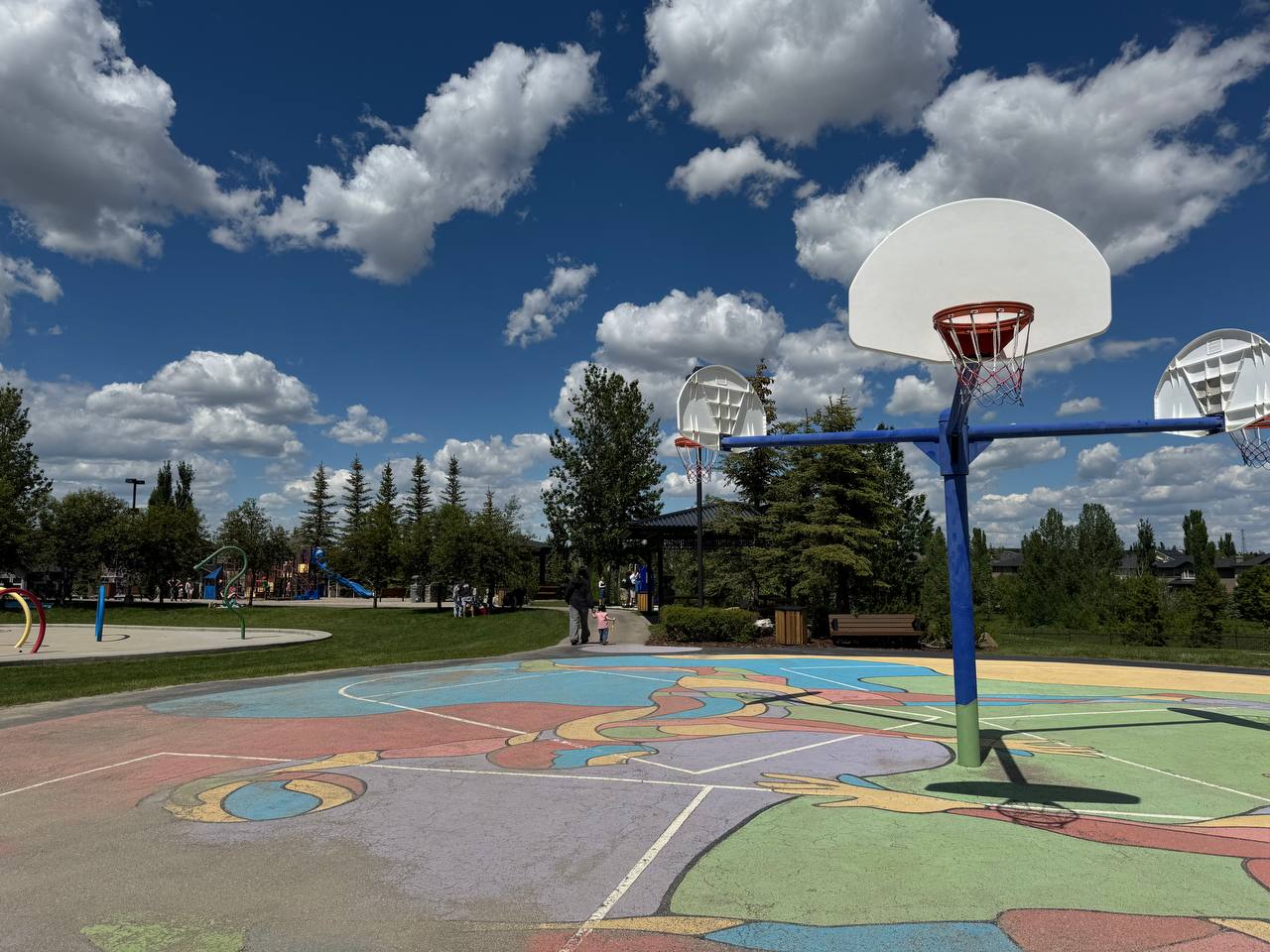 Colorful basketball court with three hoops at Panorama Hills community park